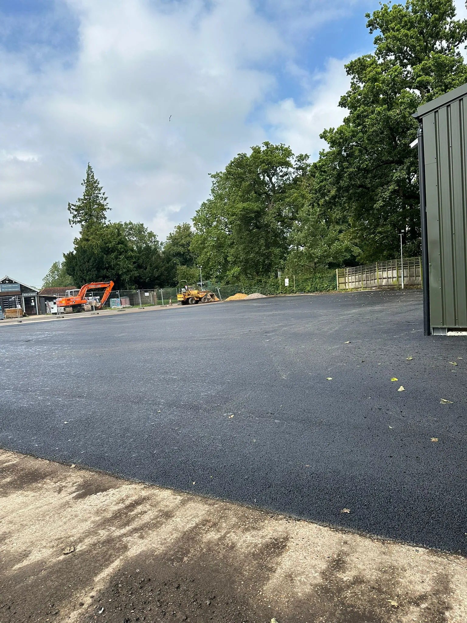 An empty parking lot with construction equipment in the background.