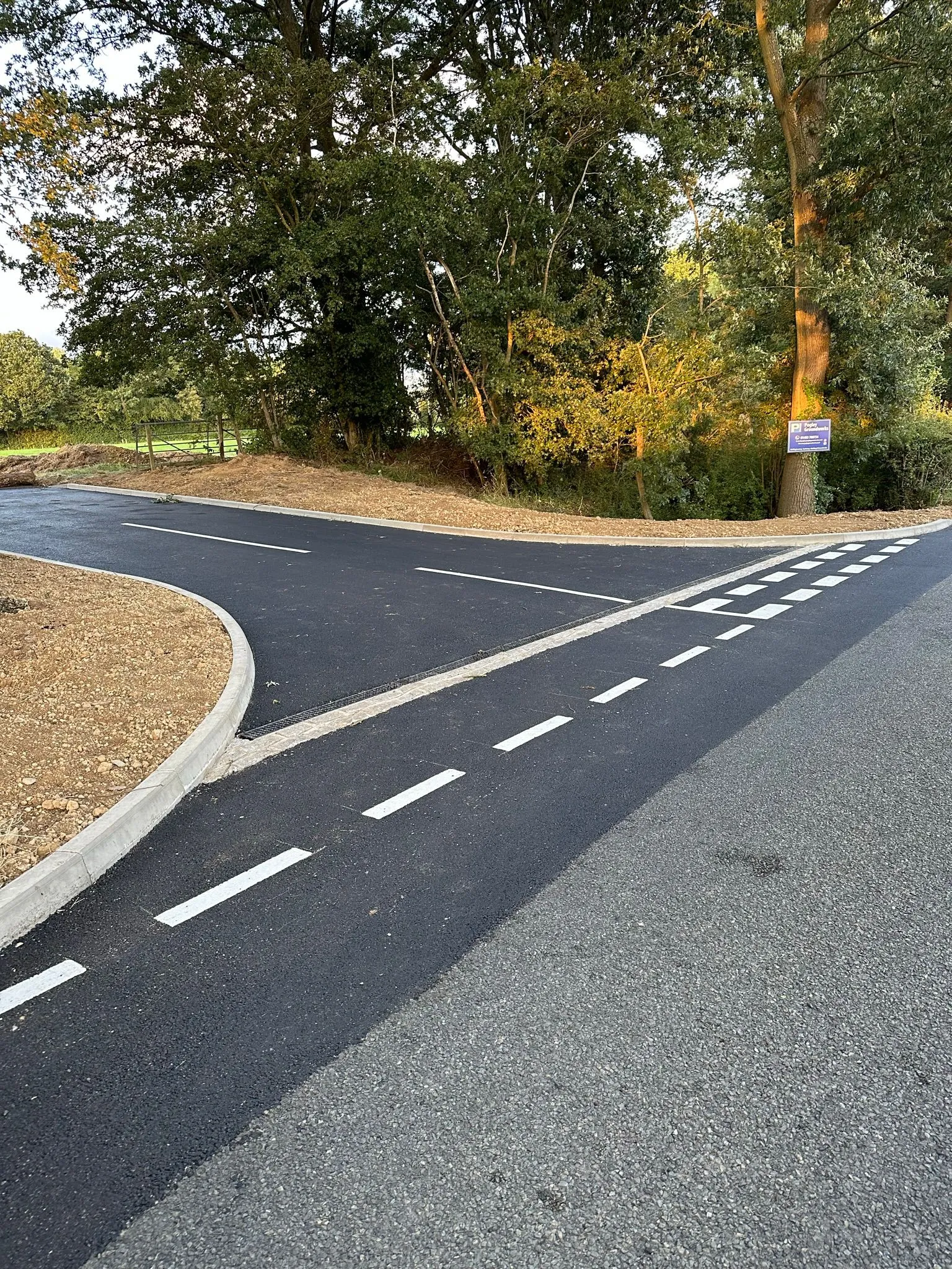 A curved road with a sign on the side of it.